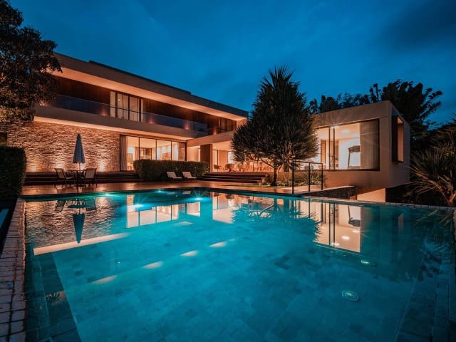 Casa de alto padrão na Granja Viana — fachada noturna com piscina